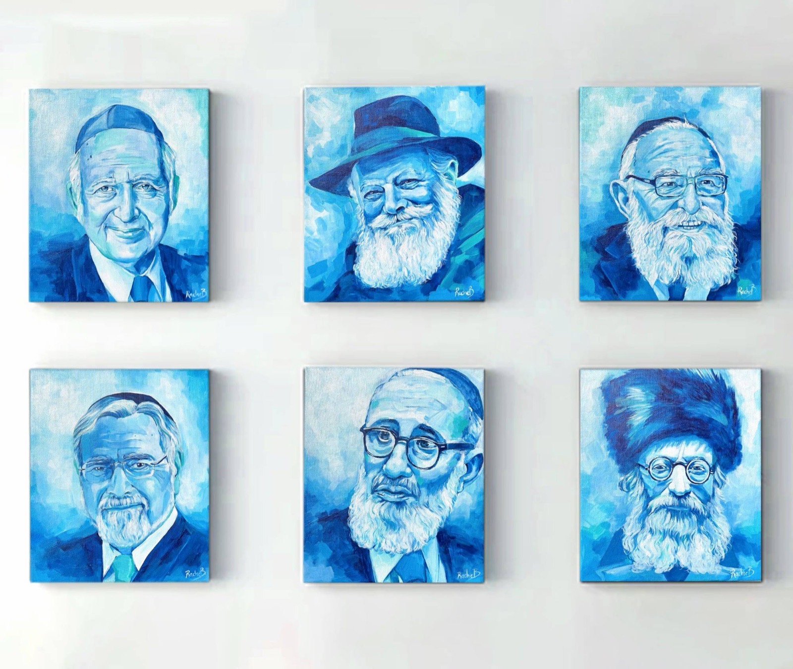 A set of six blue acrylic portraits of rabbinic leaders by Rachel Teeger, hanging together on one wall